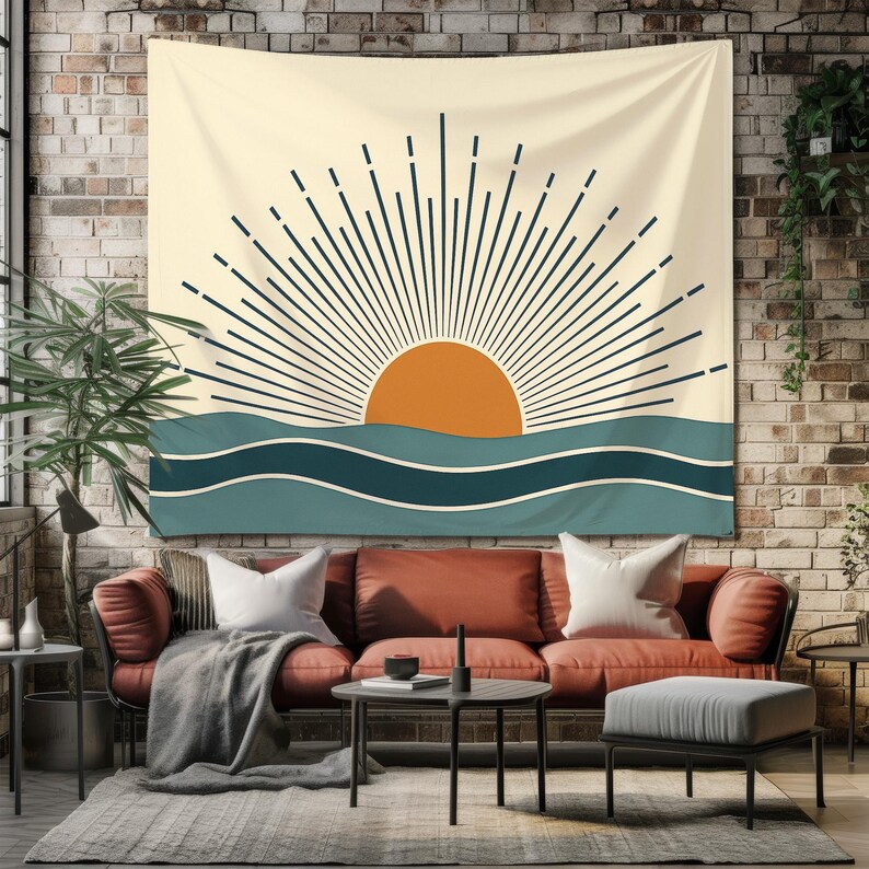Pu&ograve; includere: Un arazzo beige con un design minimalista raffigurante un sole arancione, con linee blu scuro, sopra onde turchesi. L'arazzo &egrave; appeso a un muro di mattoni, sopra un divano rosso, creando un'atmosfera calda e invitante.