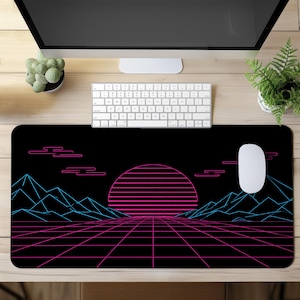 Pode incluir: Tapete de mesa retangular preto com um design retrô dos anos 80. O tapete apresenta uma paisagem rosa e azul neon com uma grade, montanhas e um sol poente. Um mouse e um teclado brancos estão na mesa.