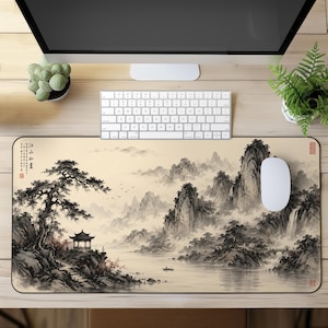 Puede incluir: Una alfombrilla de escritorio rectangular con una ilustración de paisaje en estilo de tinta monocromática. La escena muestra montañas brumosas, un río, un pabellón tradicional, un bote solitario y un pino, con caligrafía china en la esquina.