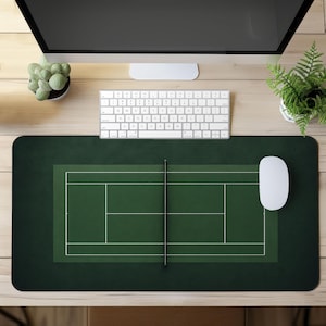 May include: A rectangular desk mat featuring a dark green surface with a printed white tennis court graphic. The design includes a central net line and court boundaries, providing a smooth workspace surface for a computer mouse and keyboard.