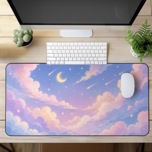 May include: A rectangular desk mat featuring a night sky illustration with soft pink and blue clouds, a yellow crescent moon, and scattered white stars with shooting stars. The mat is positioned on a wooden desk surface below a computer.