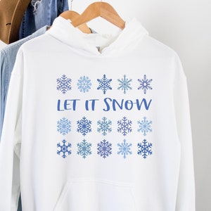 May include: White hooded sweatshirt with a blue and white snowflake design and the text "Let It Snow".