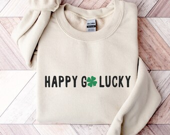 May include: A sand-colored sweatshirt with the text "HAPPY G LUCKY" and a green four-leaf clover graphic.