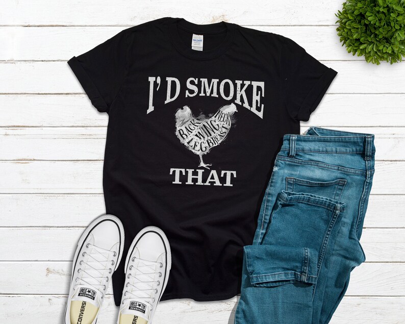 May include: Black t-shirt with a white graphic of a chicken with the words "I'd Smoke That" printed on it. The chicken is labeled with different parts of the bird, such as "back", "wing", and "leg".
