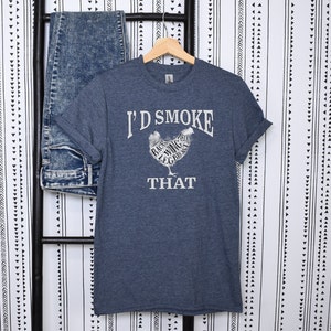 May include: A dark blue t-shirt with a white graphic of a chicken with the text "I'd Smoke That" and the different parts of the chicken labeled.