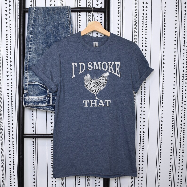May include: A dark blue t-shirt with a white graphic of a chicken with the text "I'd Smoke That" and the different parts of the chicken labeled.