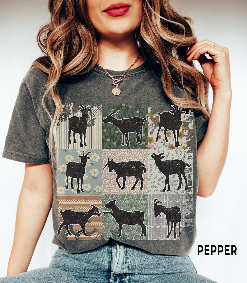 May include: A dark gray t-shirt with a patchwork design featuring nine black silhouettes of goats. Each square in the patchwork has a different floral or geometric pattern. The text "PEPPER" is printed in white on the bottom right corner of the shirt.