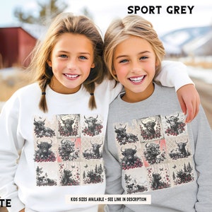 May include: Two girls wearing sweatshirts with a patchwork design featuring a repeated pattern of black and white Highland cows. The sweatshirt on the left is white and the sweatshirt on the right is gray. The text "SPORT GREY" is at the top of the image and the text "WHITE" is at the bottom left of the image. The text "KIDS SIZES AVAILABLE - SEE LINK IN DESCRIPTION" is at the bottom of the image.