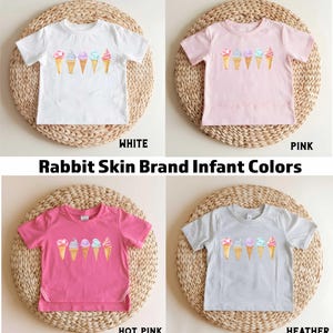 May include: Four infant t-shirts with a graphic of ice cream cones. The shirts are in white, pink, hot pink, and heather grey.