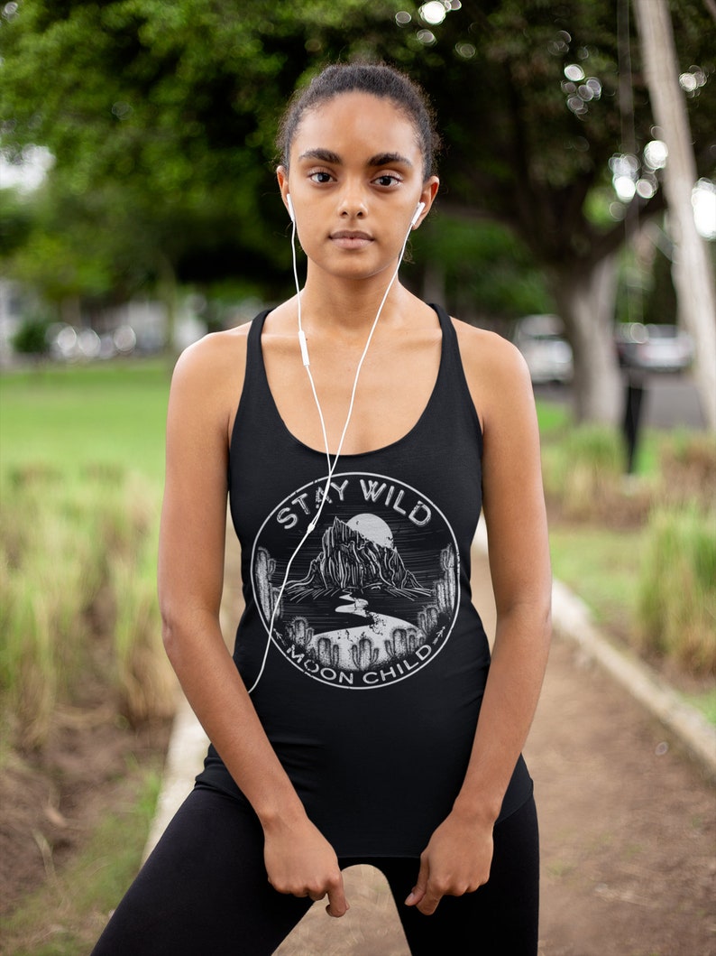 May include: A black tank top with a white graphic print of a mountain range, a moon, and the text "Stay Wild Moon Child".