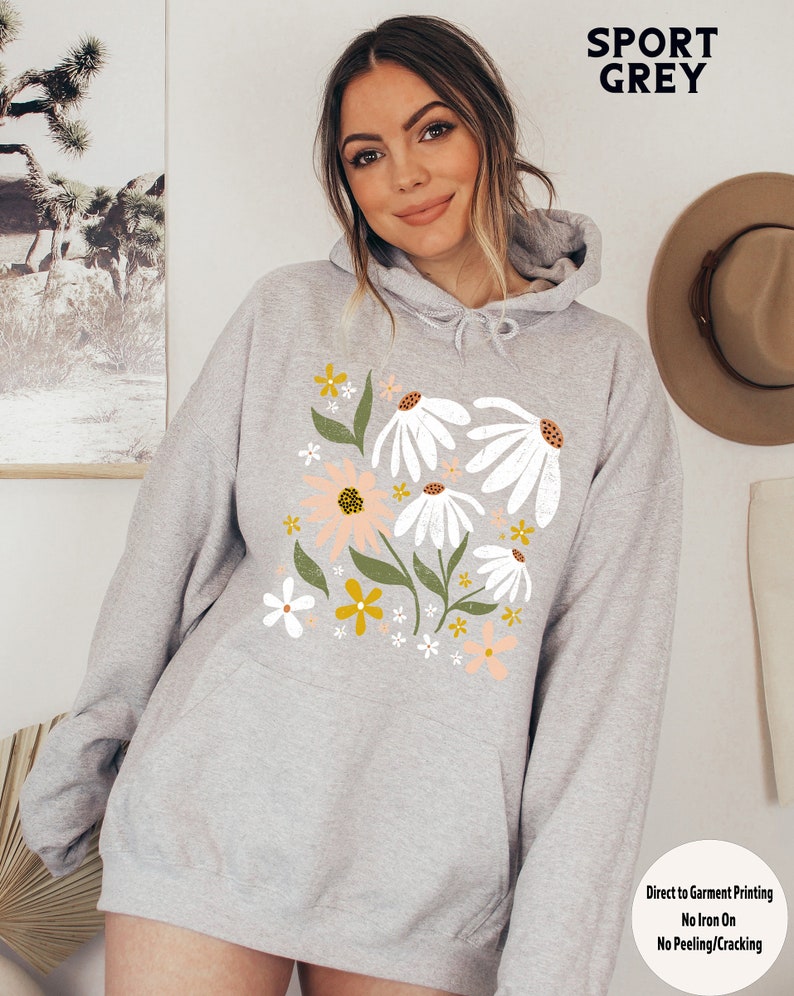 K&ouml;nnte beinhalten: Ein grauer Kapuzenpullover mit einem Blumendruck mit wei&szlig;en G&auml;nsebl&uuml;mchen, rosa und gelben Blumen und gr&uuml;nen Bl&auml;ttern. Der Text "SPORT GREY" ist oben im Bild in Schwarz gedruckt. Der Text "Direct to Garment Printing No Iron On No Peeling/Cracking" ist unten im Bild gedruckt.