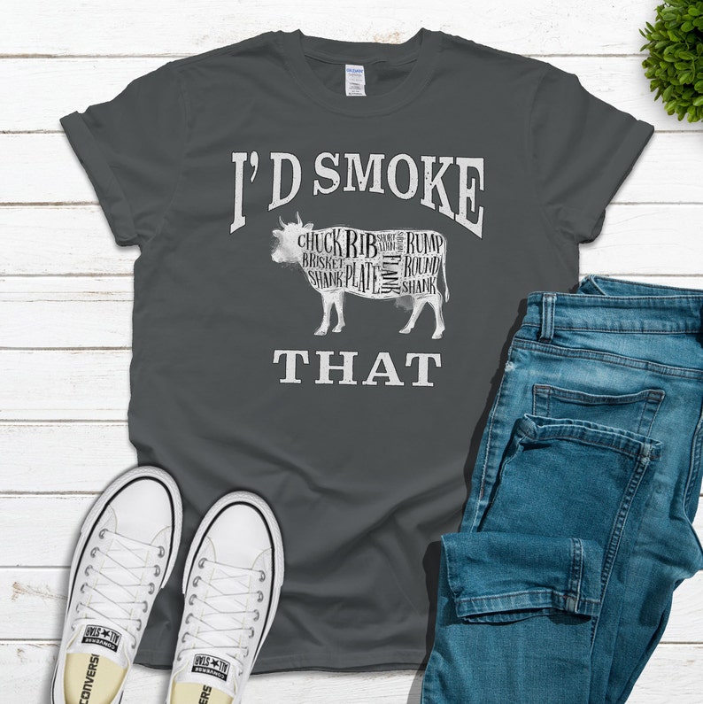 Puede incluir: Una camiseta gris oscuro con el texto "I'd Smoke That" y una silueta de una vaca con diferentes cortes de carne etiquetados.