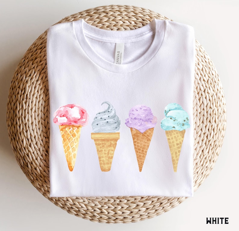 May include: White t-shirt with a graphic of four ice cream cones in different flavors: pink, gray, purple, and blue. The text "Canvas" is visible on the shirt.