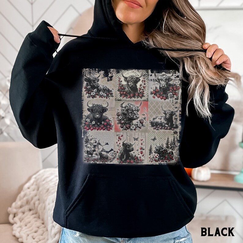 May include: Black hoodie with a patchwork design featuring multiple images of Highland cattle with red berries and flowers. The hoodie has a drawstring hood and a kangaroo pocket.