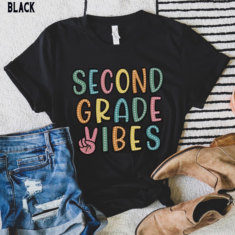 May include: Black t-shirt with the text "Second Grade Vibes" in colorful letters with a peace sign graphic.
