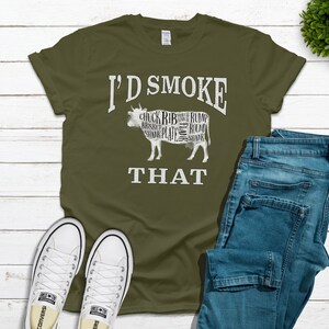 Puede incluir: Una camiseta verde con el texto "I'd Smoke That" y una silueta de una vaca con los diferentes cortes de carne etiquetados.