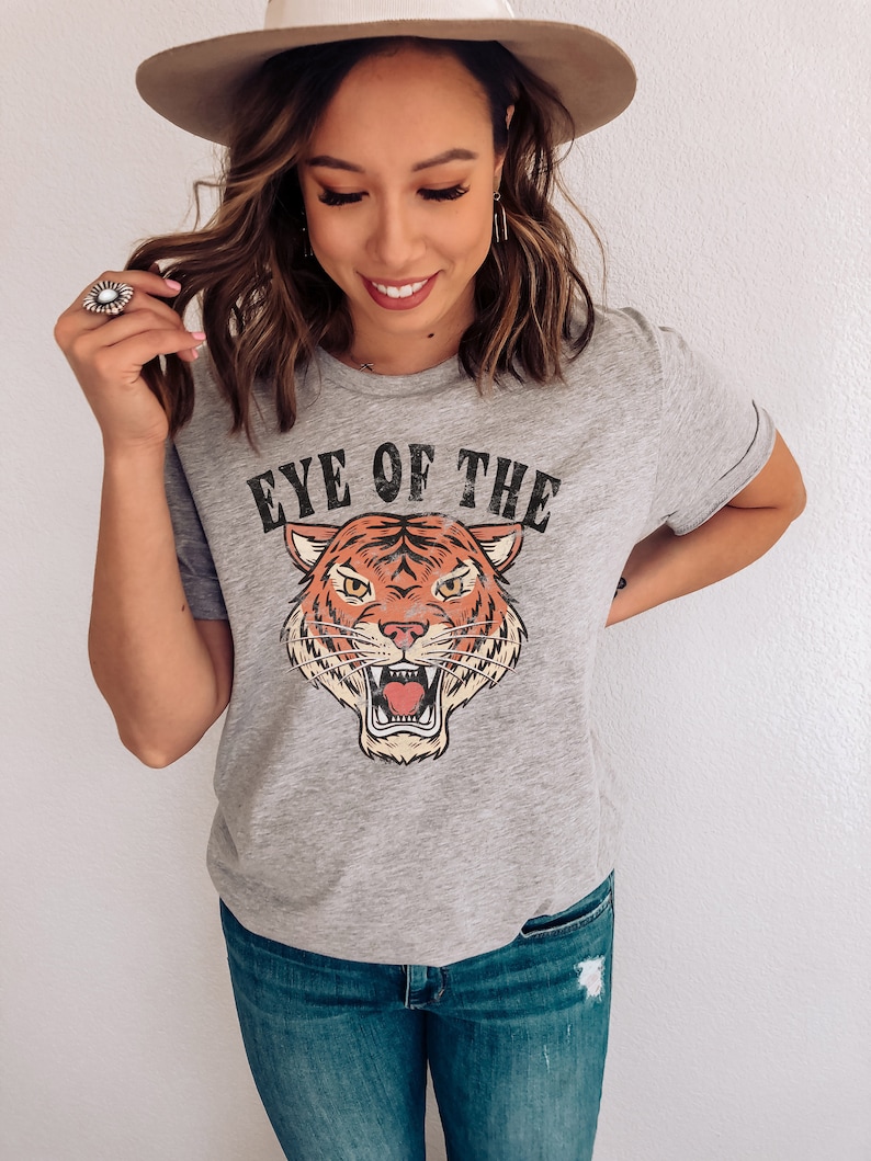 May include: Gray t-shirt with a vintage-style tiger graphic and the text "Eye of the Tiger".