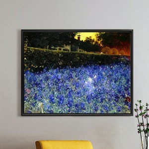 May include: A framed print of a landscape scene with a field of blue flowers in the foreground and a house in the background. The print is hanging on a white wall above a yellow armchair.