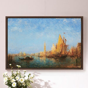 Può includere: Un dipinto incorniciato di un paesaggio marittimo con una barca a vela e uno skyline di città sullo sfondo. Il dipinto è appeso a una parete bianca sopra un mobile in legno con un vaso di fiori bianchi e due uccelli decorativi.