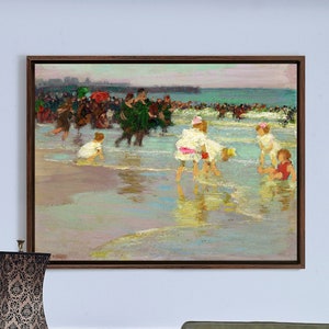 Puede incluir: Una pintura que representa una escena de playa con niños jugando en el agua. La pintura está enmarcada en marrón y cuelga de una pared azul claro. Hay una lámpara y una mesa auxiliar en primer plano.