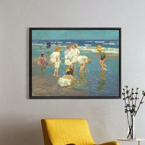 Puede incluir: Una pintura enmarcada que representa a un grupo de niños jugando en el agua poco profunda de una playa. Los niños visten ropa de verano y se dedican a diversas actividades, como construir castillos de arena y chapotear en el agua. La pintura tiene como fondo un cielo azul y una playa de arena.