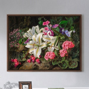 May include: A framed painting of a still life featuring white lilies, pink geraniums, and purple morning glories. The flowers are arranged on a bed of green leaves and rocks.
