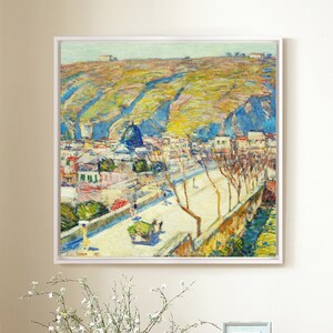 May include: A painting of a cityscape with a hill in the background. The city is painted in a bright, colorful style with a mix of blues, yellows, and greens. The hill is painted in a more muted palette of browns and greens. The painting is framed in a white frame.