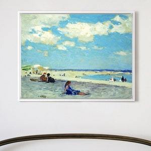 Puede incluir: Una pintura que representa una escena de playa con gente en la arena y en el agua. El cielo es azul con nubes blancas. La pintura está enmarcada en un marco blanco.