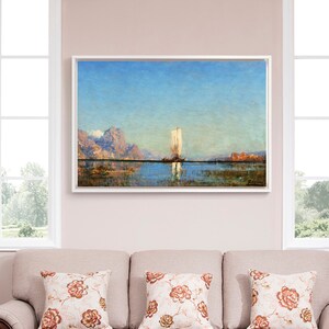 Può includere: Un divano beige con tre cuscini, di cui due con un motivo floreale in tonalità di marrone e bianco. Il divano è davanti a un muro con un dipinto incorniciato di una barca a vela su uno specchio d'acqua con montagne sullo sfondo.