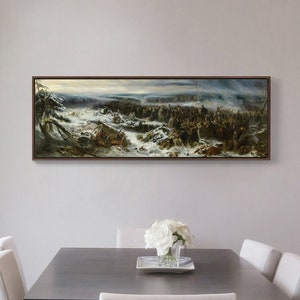 Puede incluir: Una pintura enmarcada que representa a un gran grupo de personas en un paisaje nevado. La pintura está en un marco marrón y está colgada en una pared gris claro sobre una mesa gris con sillas blancas.