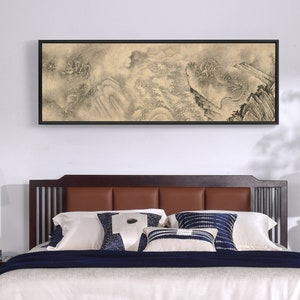 May include: A brown wooden bed frame with a brown leather headboard and a white and blue patterned throw pillow. The bed is made with white linens and a dark blue blanket. A black framed painting of a dragon in the clouds hangs above the bed.