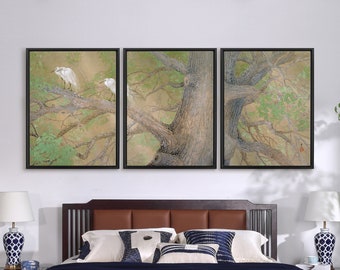 May include: A set of three framed prints depicting a large tree with white birds perched on its branches. The tree is painted in shades of green, brown, and beige, with a light brown background. The frames are black.