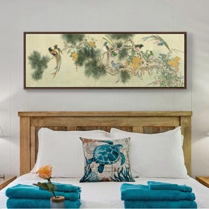 May include: A framed artwork depicts colorful birds perched on a flowering branch. The artwork features a cream-colored background with a dark brown frame. The birds have long tail feathers and are surrounded by yellow flowers and green foliage. The artwork is displayed above a wooden headboard.