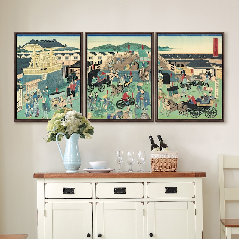 May include: A set of three framed Japanese woodblock prints depicting a bustling street scene with people, horses, and carriages. The prints are in a traditional style with vibrant colors and intricate details.