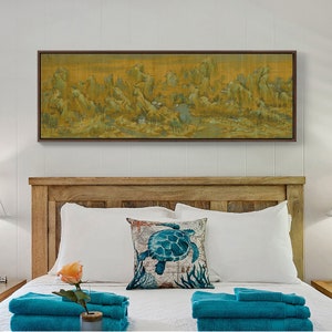May include: A framed landscape painting of a mountain range with a river running through it. The painting is hanging above a wooden headboard with white bedding and a blue and white pillow with a sea turtle design.