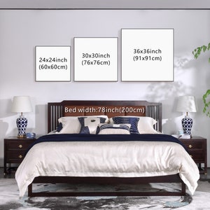 May include: Three white framed canvas prints with black text showing different sizes in inches and centimeters. The prints are hanging on a white wall above a brown wooden bed with a white linen headboard and white bedding. The bed is 78 inches (200 cm) wide.