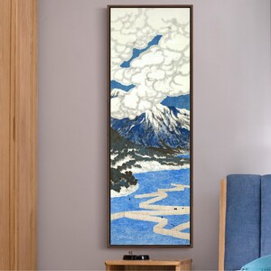 May include: A vertical painting of a mountain landscape with a large white cloud in the sky. The mountain is blue and green with a white snow cap. The water is blue and there is a white path winding through it.