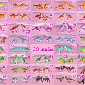 Può includere: Una collezione di 39 diversi stili di ciondoli di dinosauri, ognuno con una coppia di dinosauri in vari colori, tra cui verde, blu, rosa, viola, arancione e giallo. I ciondoli sono disposti in una griglia su uno sfondo rosa.
