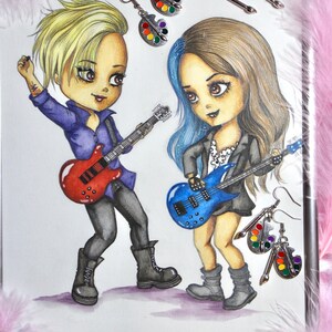 Op de afbeelding: Twee cartoonfiguren, een met blond haar en een met blauw en bruin haar, spelen elektrische gitaren. De blonde figuur draagt een paars shirt en een zwarte broek. De figuur met blauw en bruin haar draagt een zwart jack en een wit shirt. Beide figuren dragen zwarte laarzen. De achtergrond is wit met zilveren verfpalette-oorbellen.