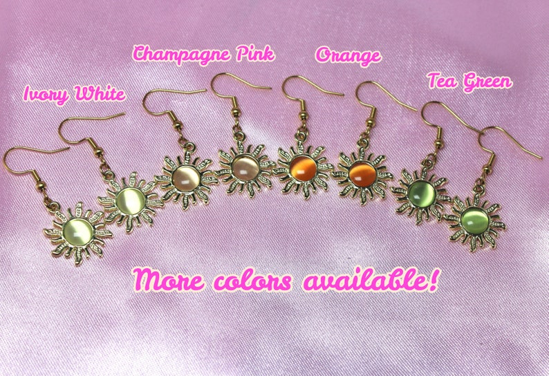 May include: Gold sun earrings with different colored glass stones. The colors are ivory white, champagne pink, orange, tea green. The text "More colors available!" is written below the earrings.