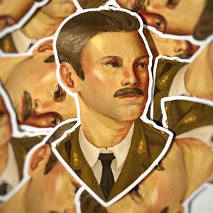 May include: A close-up of a sticker featuring a man in a military uniform. He has short brown hair, a mustache, and is wearing a green uniform with gold buttons. The sticker is surrounded by other stickers of the same man.
