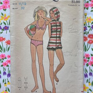 May include: A vintage Butterick 6220 sewing pattern envelope for a two-piece bikini and a hooded romper. The illustration shows two figures, one in a pink bikini with a sun hat and one in a striped hooded romper, with size 11/12 and bust 32 printed.