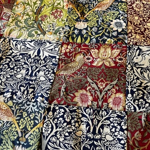 May include: A patchwork quilt composed of fabric squares with floral and bird designs. The colour scheme includes green, blue, red, and cream tones. The quilt's design displays a blend of botanical and avian motifs, creating a vintage aesthetic.