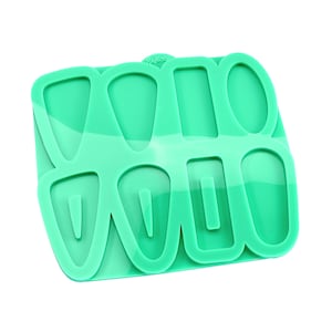 May include: Green silicone mould with eight cavities for making resin earrings. The mould features two different shapes: a teardrop and a rectangle.