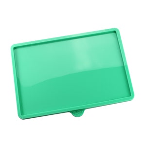 May include: A green silicone tray with the word "remarkable" printed on the bottom.