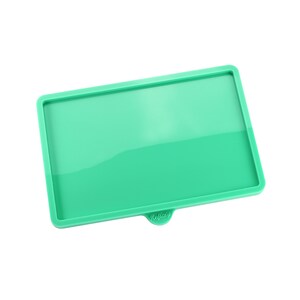 May include: A green silicone tray with a raised edge and the word "Reflat" printed on the bottom.
