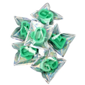 May include: A set of six green plastic cookie cutters shaped like the letters G, O, L, D, E, and N, individually packaged in clear plastic bags with a holographic finish.