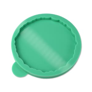 Può includere: Uno stampo in silicone verde con un bordo a festoni, progettato per creare oggetti rotondi in resina.