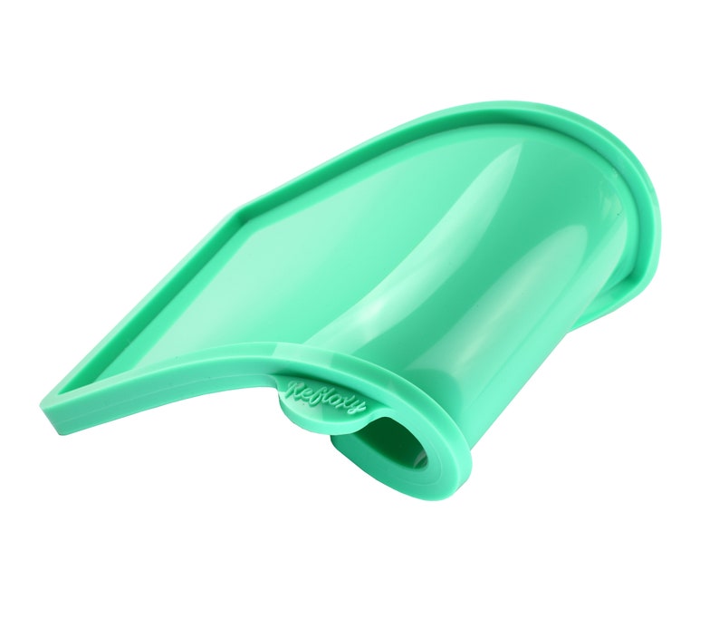 May include: A green silicone baking mold shaped like a curved rectangle. The mold has a raised edge and the word "Refloxy" is printed on the side.