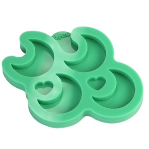 May include: Green silicone mould with three crescent moon shapes and two heart shapes. The mould is designed for making resin crafts.